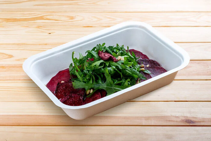 Mittagessen Carpaccio aus Rote Beete, Rucola und Nüssen